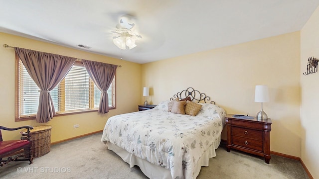 carpeted bedroom featuring baseboards, a ceiling fan, and visible vents
