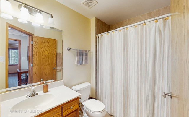 bathroom with vanity, toilet, curtained shower, and visible vents