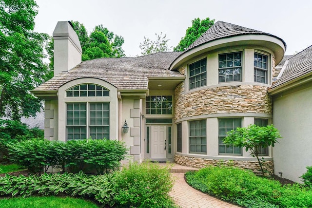 590 Academy Woods Dr, Lake Forest, IL 60045 - property entrance with stone siding, stucco siding, and a chimney