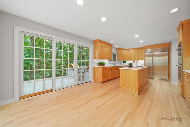 590 Academy Woods Dr, Lake Forest, IL 60045 - kitchen with appliances with stainless steel finishes, a center island, light countertops, light wood-style floors, and recessed lighting