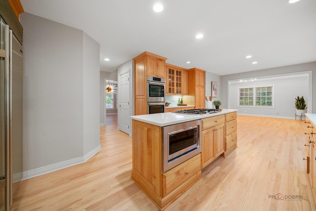 590 Academy Woods Dr, Lake Forest, IL 60045 - kitchen with stainless steel appliances, light wood finished floors, light countertops, a kitchen island, and recessed lighting