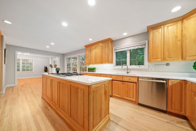 590 Academy Woods Dr, Lake Forest, IL 60045 - kitchen featuring appliances with stainless steel finishes, a center island, light wood finished floors, light countertops, and healthy amount of natural light