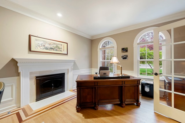 office area with light wood-type flooring, a fireplace, and crown molding