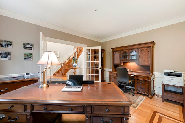home office featuring ornamental molding, light wood-style flooring, and a wainscoted wall