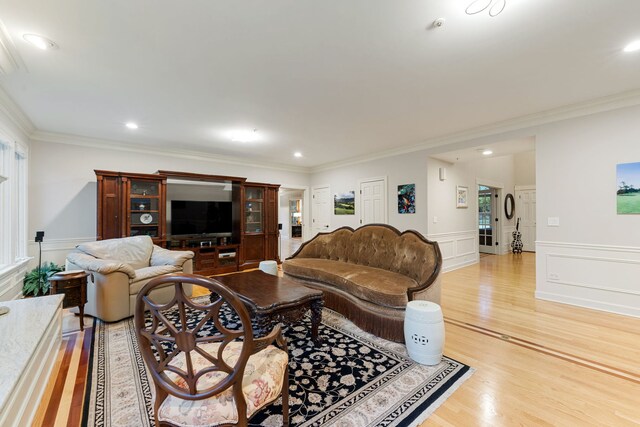 living room with crown molding, light wood-style flooring, wainscoting, and recessed lighting