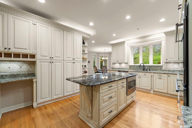 kitchen featuring open shelves, a center island, light wood-style floors, tasteful backsplash, and recessed lighting