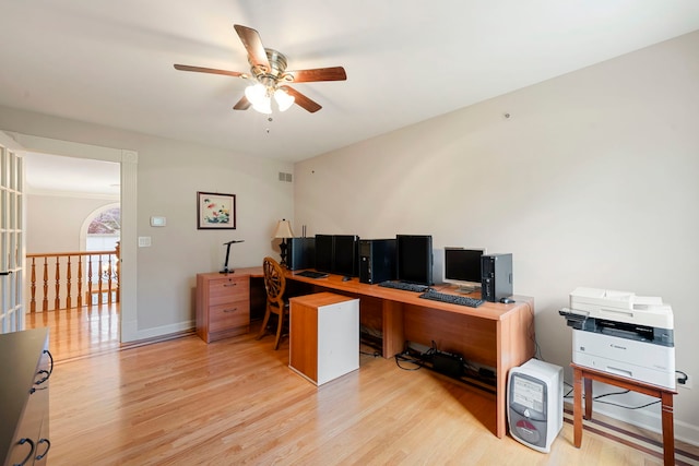 home office featuring light wood finished floors, a ceiling fan, and baseboards