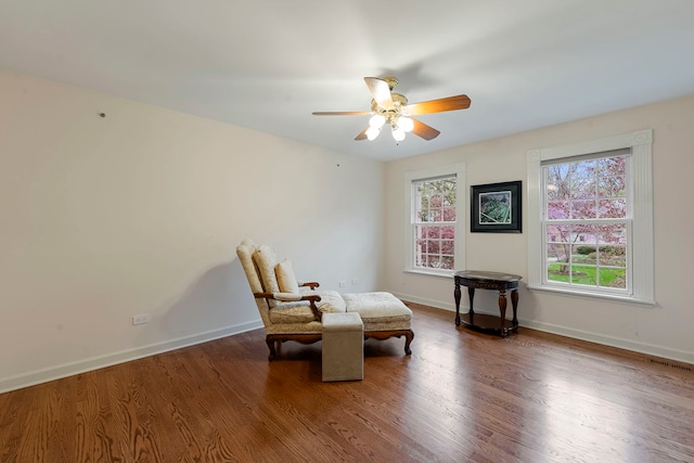 living area featuring wood finished floors, ceiling fan, and baseboards