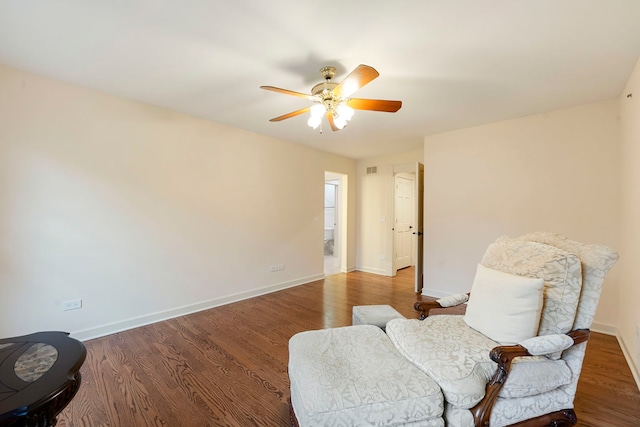 living area featuring a ceiling fan, baseboards, and wood finished floors