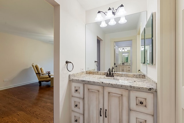 bathroom featuring wood finished floors, a chandelier, and vanity