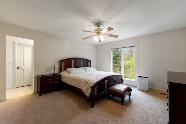 bedroom featuring light colored carpet, ceiling fan, and baseboards