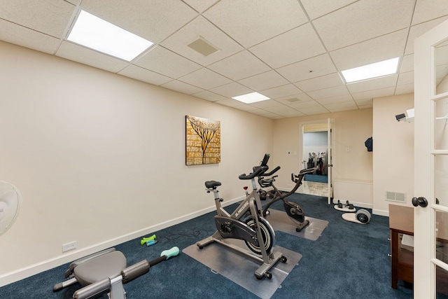 workout area featuring a drop ceiling, baseboards, and carpet flooring
