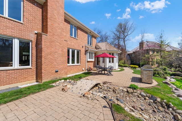 back of house featuring a patio and brick siding
