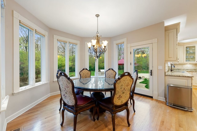 dining space featuring a chandelier, healthy amount of natural light, and light wood-style floors