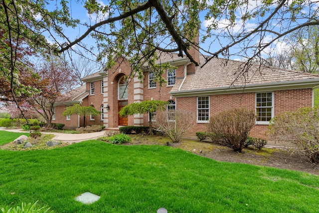 view of front of house featuring brick siding and a front lawn