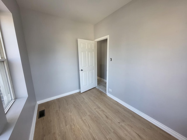 spare room featuring baseboards, visible vents, and light wood-type flooring