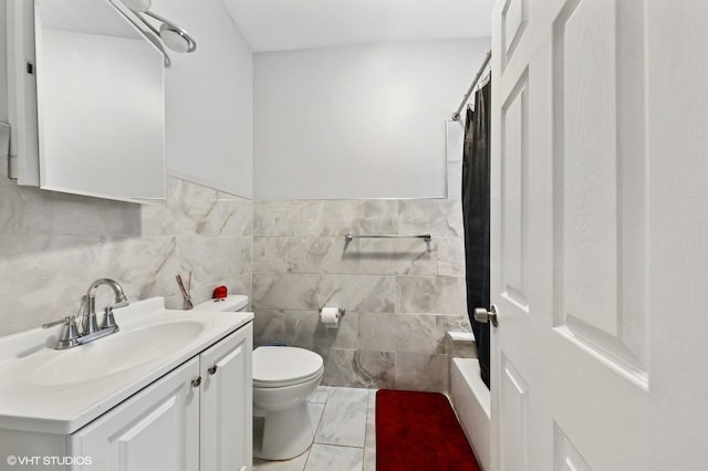 full bathroom with tile walls, a wainscoted wall, vanity, and toilet