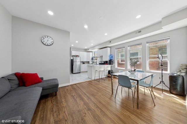 dining space with recessed lighting, baseboards, visible vents, and light wood-style floors