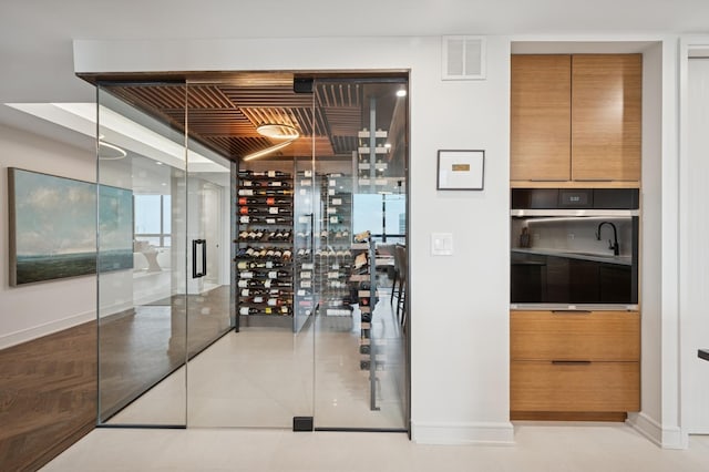 wine area with baseboards, visible vents, and tile patterned flooring