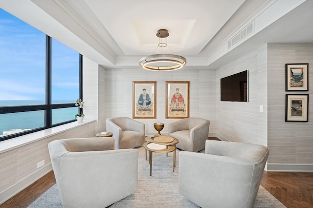 sitting room with visible vents, baseboards, and a tray ceiling