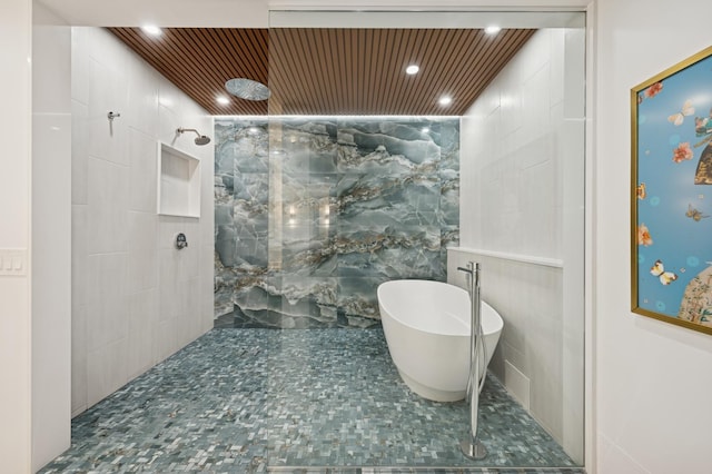 full bath with a walk in shower, tile walls, a soaking tub, and recessed lighting
