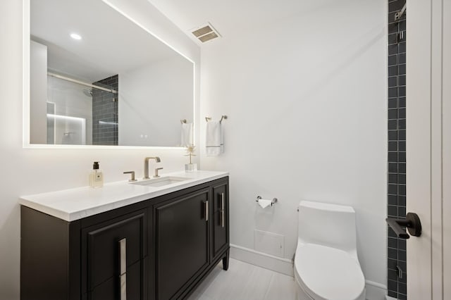 bathroom featuring visible vents, baseboards, vanity, toilet, and tiled shower