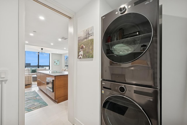 clothes washing area with laundry area, stacked washer and clothes dryer, visible vents, and recessed lighting