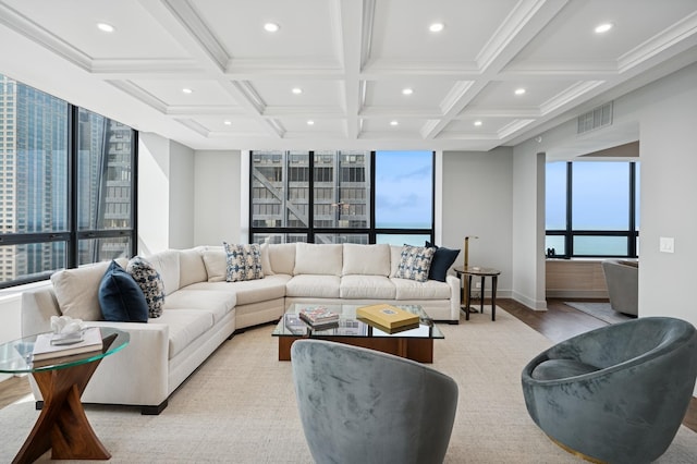 living area featuring visible vents, light wood-type flooring, a wealth of natural light, and coffered ceiling