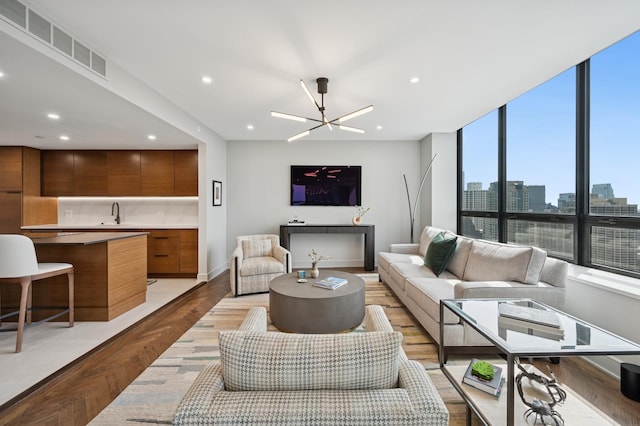 living room with recessed lighting, baseboards, visible vents, and light wood finished floors