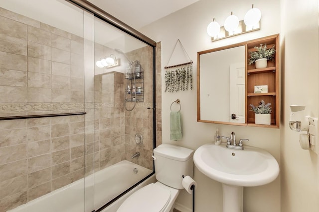 full bathroom with toilet, combined bath / shower with glass door, and a sink