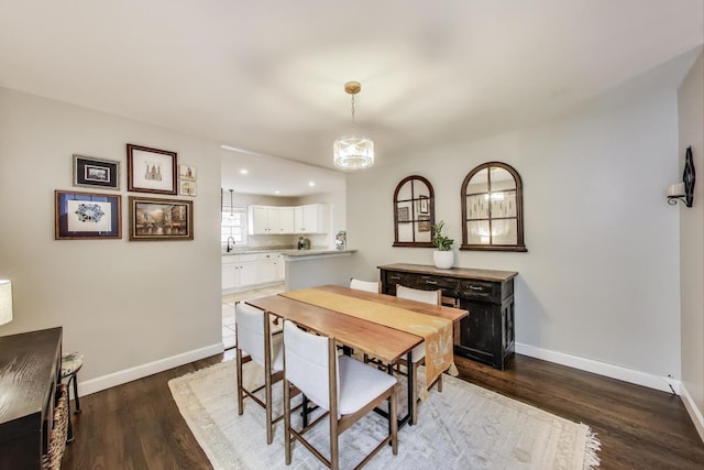 dining space with baseboards, wood finished floors, and recessed lighting