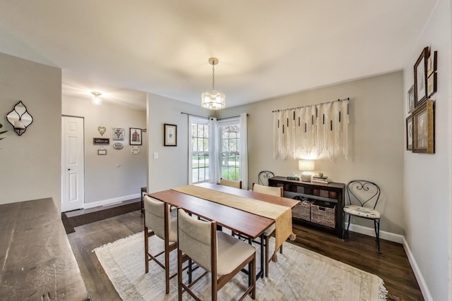 dining space featuring wood finished floors and baseboards