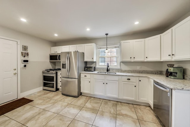 kitchen with appliances with stainless steel finishes, a sink, white cabinets, recessed lighting, and light tile patterned floors