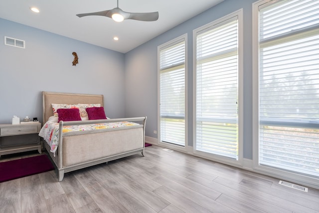 bedroom featuring ceiling fan, wood finished floors, and visible vents