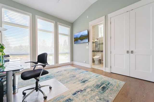 office featuring baseboards, wood finished floors, and lofted ceiling