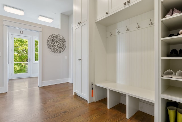 mudroom featuring baseboards and dark wood-style floors