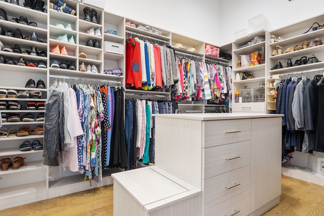 walk in closet with light wood-style floors