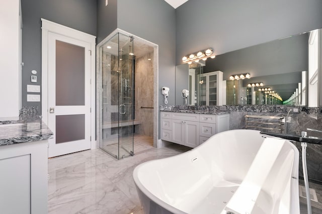 full bath featuring vanity, marble finish floor, a stall shower, and a freestanding tub