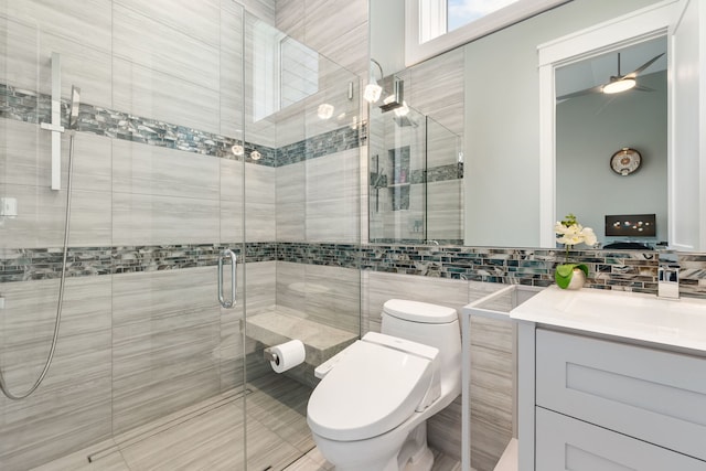 full bath with toilet, a stall shower, tile walls, and vanity