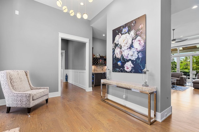 interior space featuring baseboards, wood finished floors, and a towering ceiling