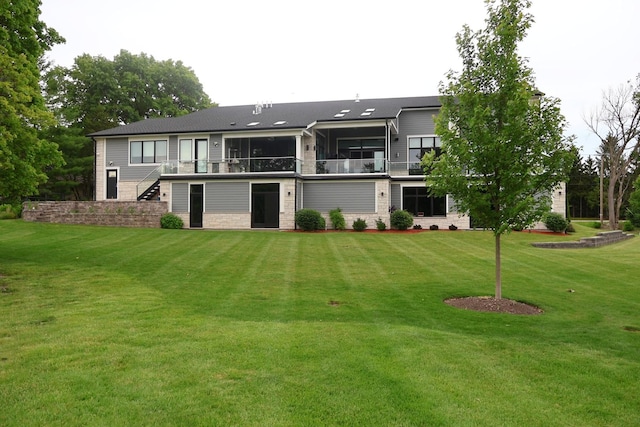 back of property featuring stairway, a yard, and stone siding