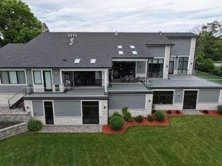 back of property with stairs and a yard