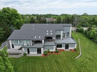 back of property featuring a lawn and a balcony