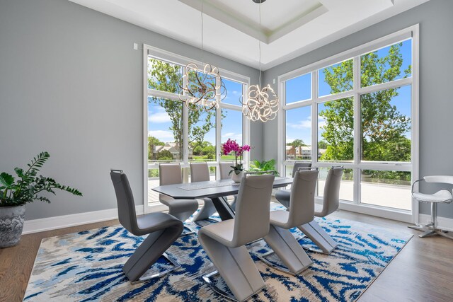 dining area featuring an inviting chandelier, baseboards, and wood finished floors