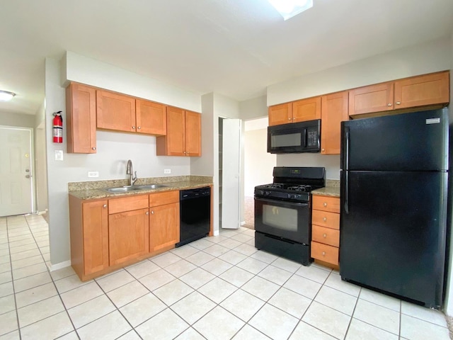 5210 Arquilla Dr, Richton Park, IL 60471 - kitchen featuring brown cabinetry, a sink, light tile patterned floors, and black appliances