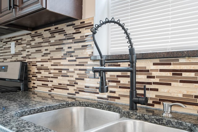 8543 S Laflin St, Chicago, IL 60620 - room details featuring decorative backsplash, a sink, and dark stone countertops