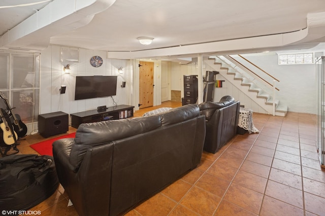 tiled living area featuring stairway and wood walls