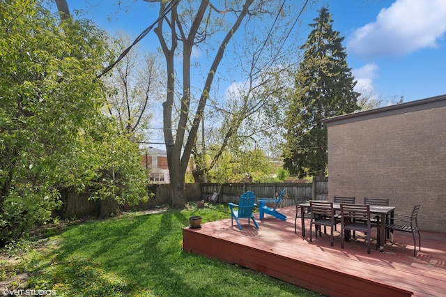 view of yard with a deck, outdoor dining area, and a fenced backyard