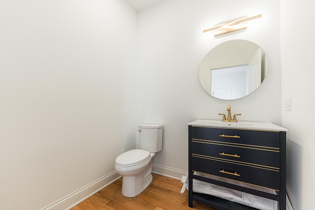 4134 W Roscoe St, Chicago, IL 60641 - half bath with wood finished floors, toilet, baseboards, and vanity