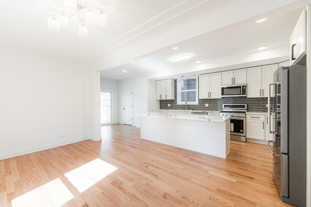 4134 W Roscoe St, Chicago, IL 60641 - kitchen with appliances with stainless steel finishes, decorative backsplash, light wood-style flooring, and a sink